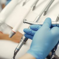 Metal instruments for the treatment of teeth. Dental clinic. Hands in a blue gloves